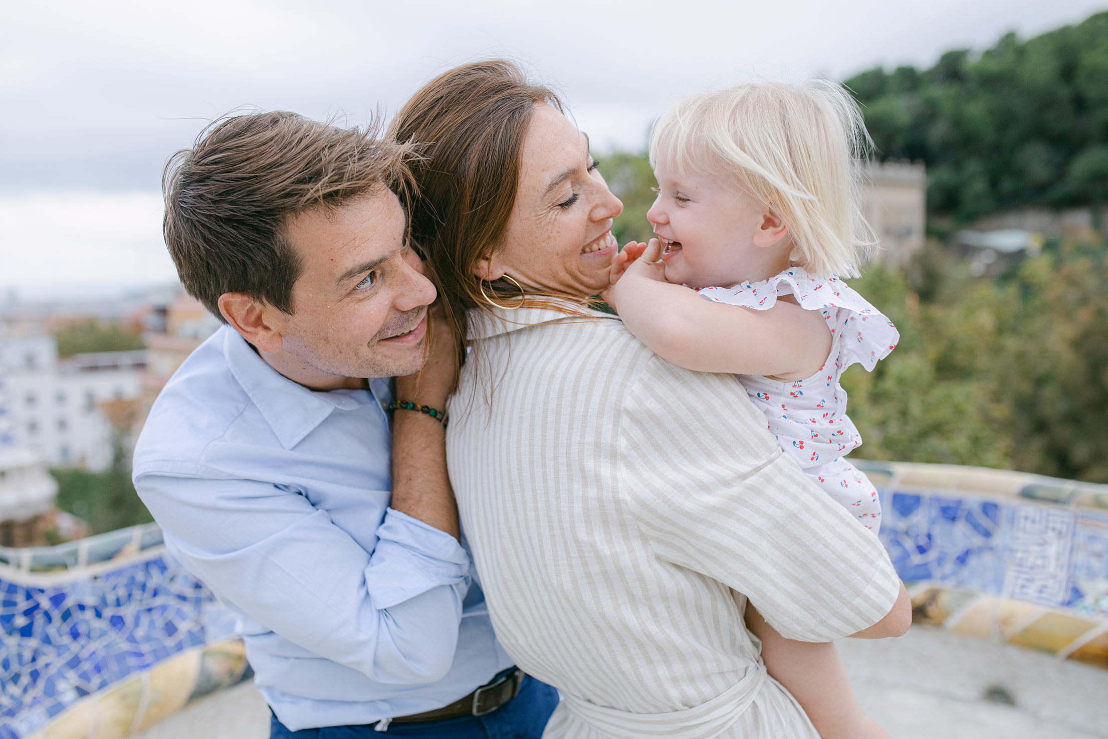 Parent playing and smiling with toddler dauther at Park Guell Barcelona Family Photographer | Lena Karelova