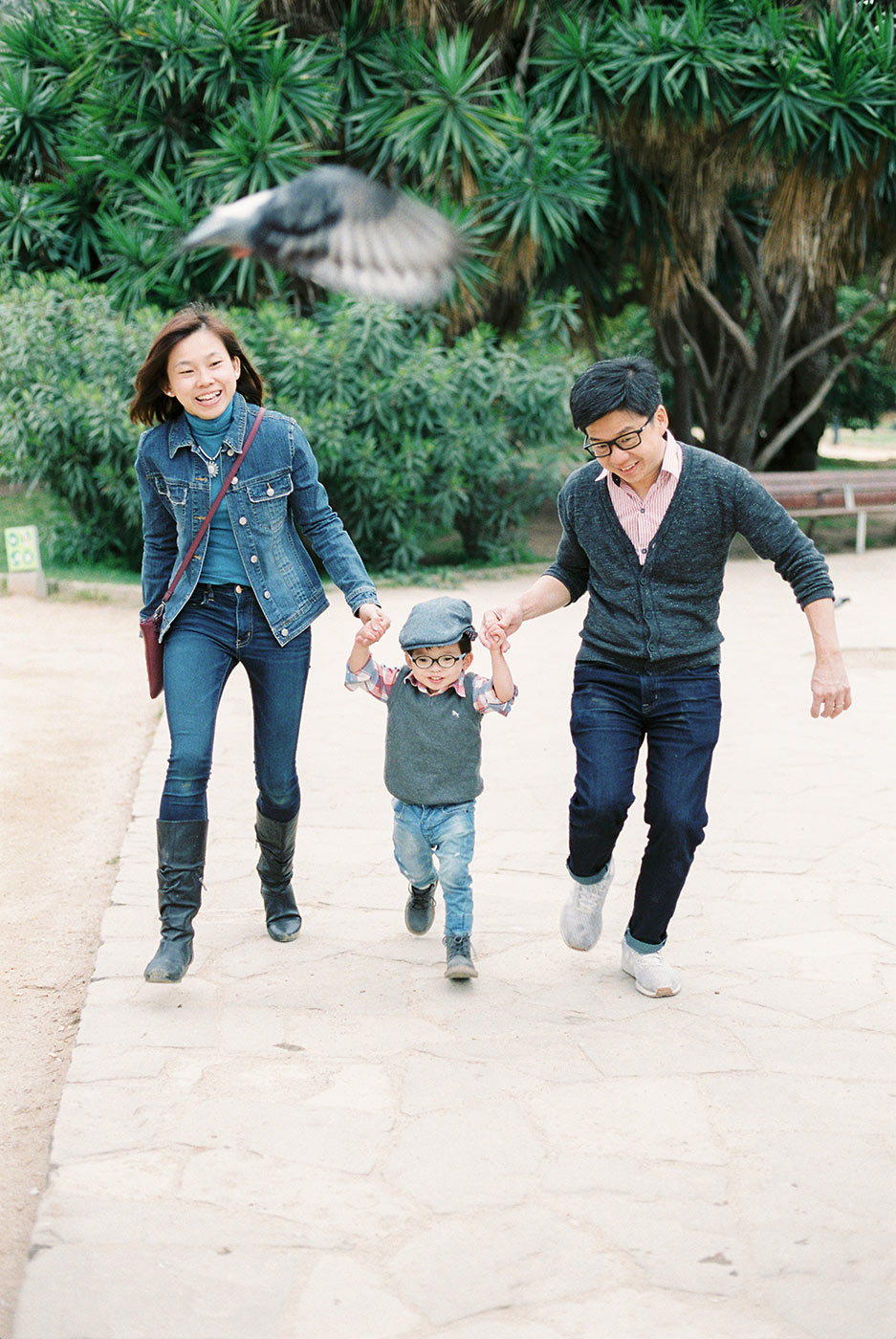 Happy family with a toddler having fun in the park of Ciutadella Barcelona | Family Photographer in Barcelona