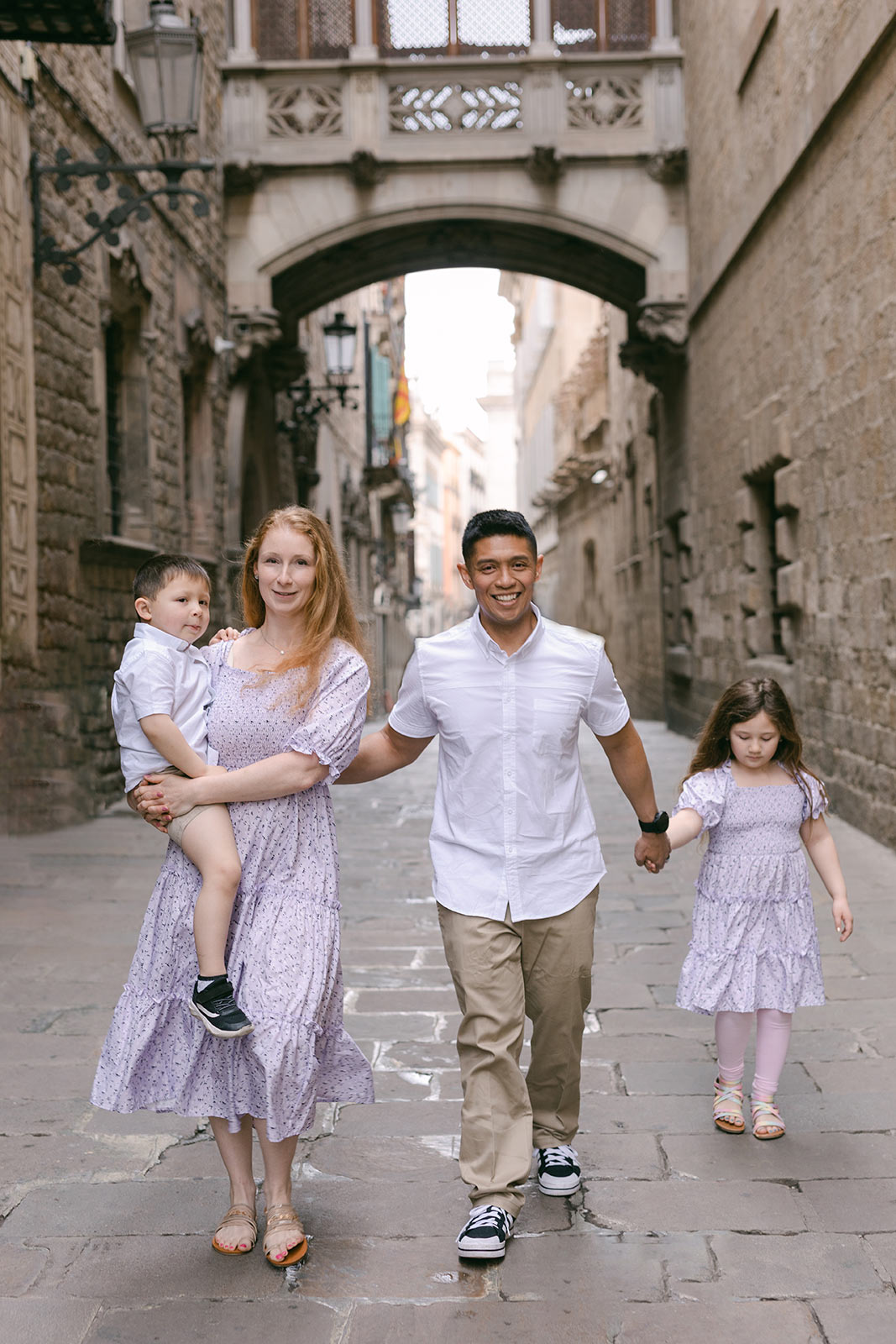 Family of four walking through Gothic quarter during family photoshoot in Barcelona