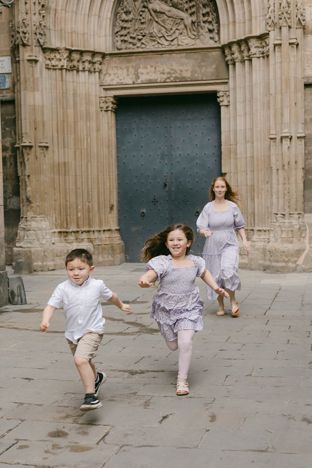 Mother and her two kids runing and having fun at the Gothic Quarter Family Photography