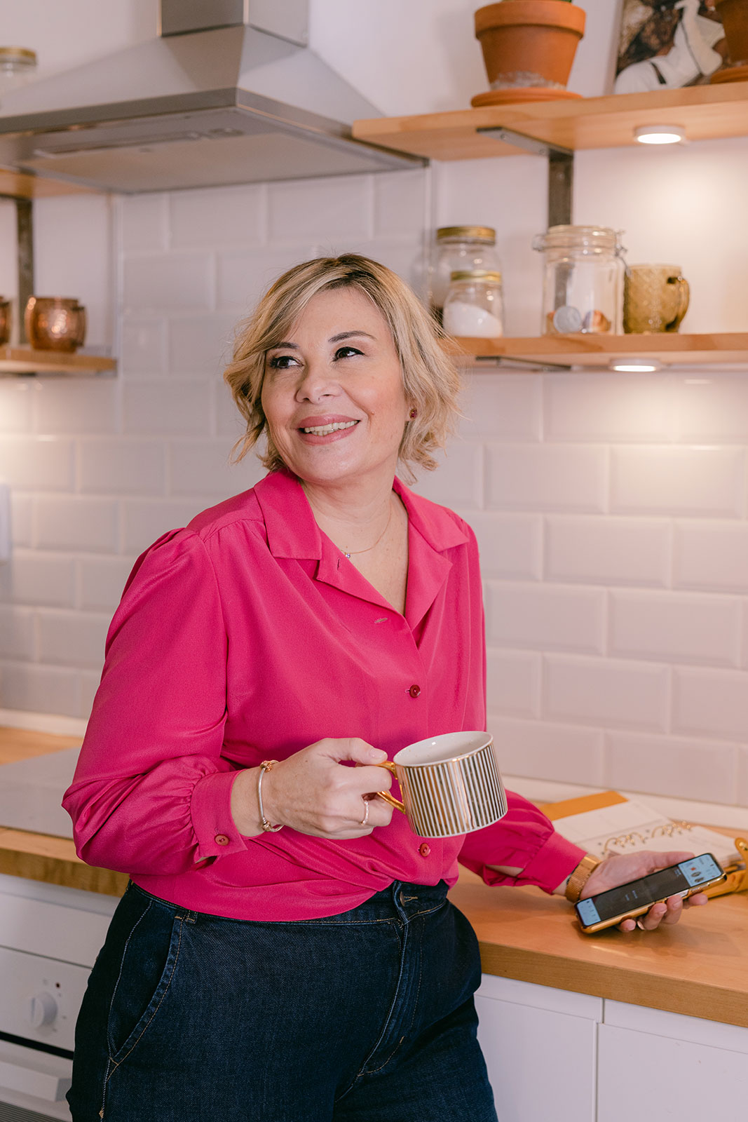 smiling senior woman wearing rose blouse works with her smartphone as a digital marketing expert