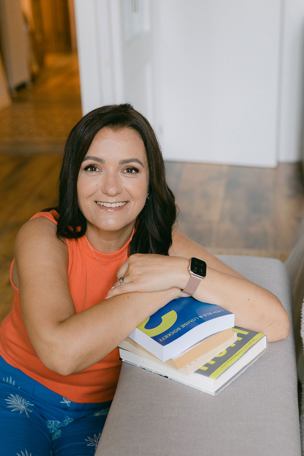 Smiling woman with books in her hands working a business coach