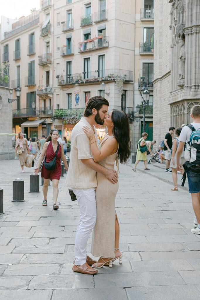 Young couple kissing on the street of El Borne after the surprise proposal in Barcelona
