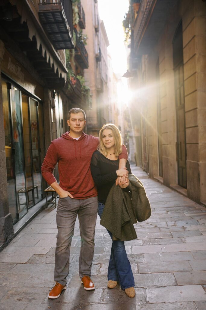 Young couple standing in the backlit during the honeymoon photoshoot in Barcelona's Gothic quarter