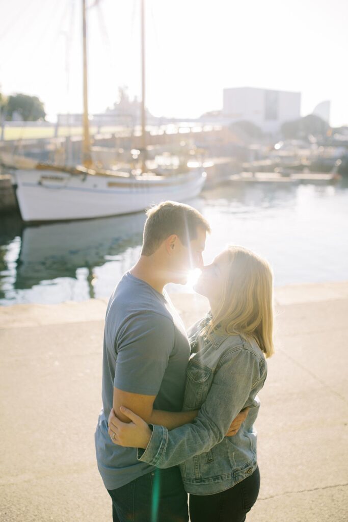 Young couple kissing at Port Vell area during the honeymoon photoshoot in Barcelona's Gothic Quarter