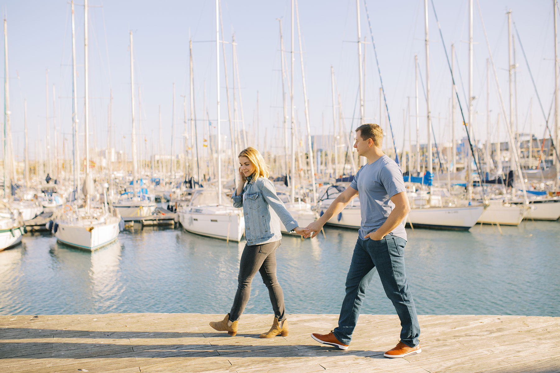 Young couple walking along the Port Vell area during the honeymoon photoshoot in Barcelona's Gothic Quarter