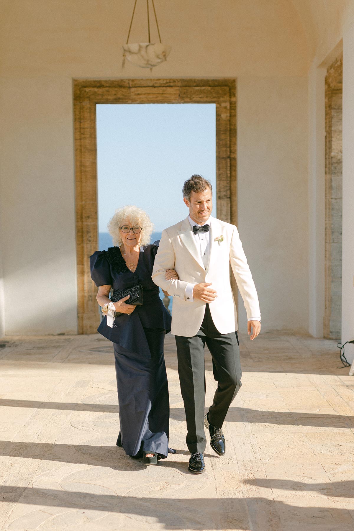 Groom walking through aisle with mother - Lena Karelova Photography Mediterranean Wedding at Luxury Hotel in Spain