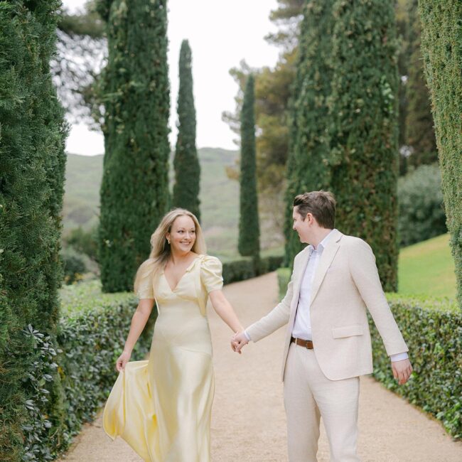 Romantic garden path lined with tall cypress trees and a sculpture at Santa Clotilde Gardens, ideal for engagement or elopement photography. Captured by an experienced Barcelona engagement photographer