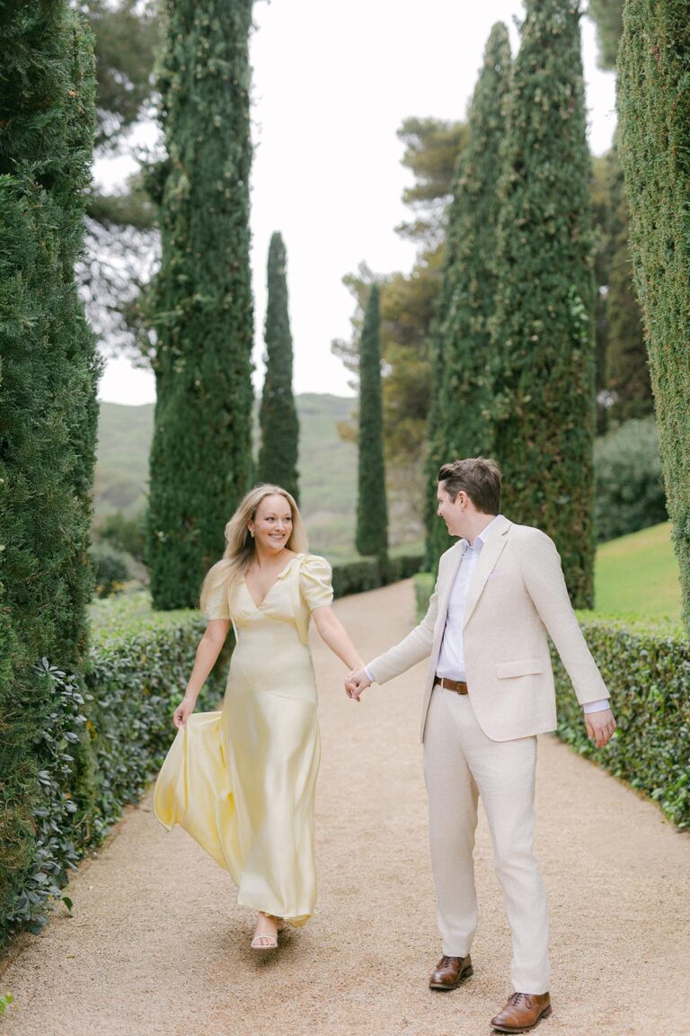 Romantic garden path lined with tall cypress trees and a sculpture at Santa Clotilde Gardens, ideal for engagement or elopement photography. Captured by an experienced Barcelona engagement photographer