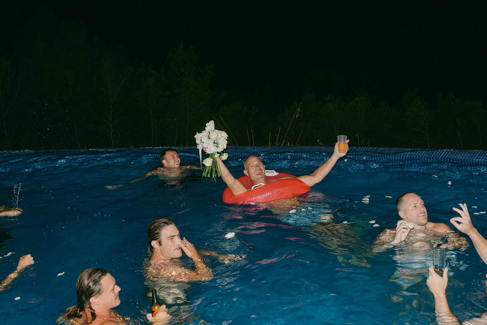 People having fun at the pool party after reception at Mediterranean villa wedding near Barcelona