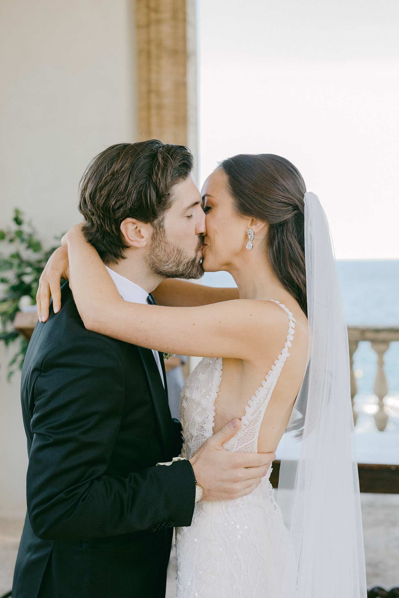 Bride and groom sharing their first kiss during the ceremony at Hostal La Gavina