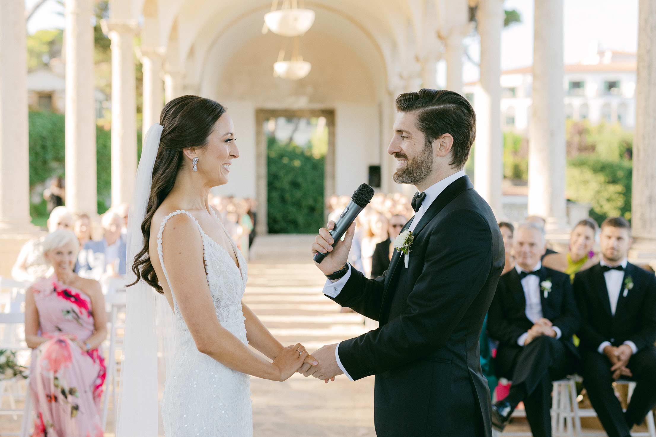 Bride and groom holding hands during their vow exchange at Hostal La Gavina in Costa Brava