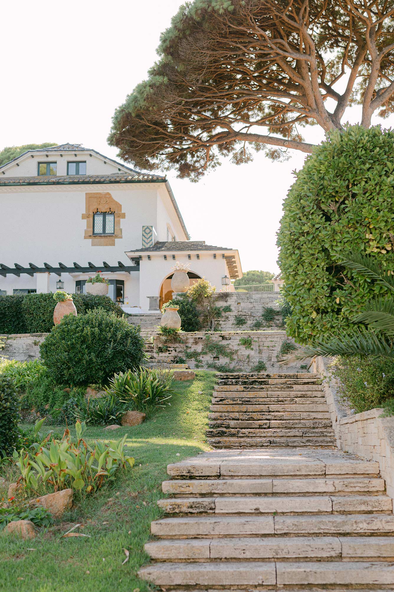 Stone steps leading to Hostal La Gavina surrounded by Mediterranean gardens in Costa Brava