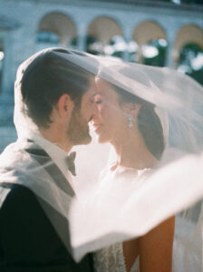 couple kissing below the veil during golden hour at Hostal La Gavina. Barcelona Wedding Photographer Lena Karelova