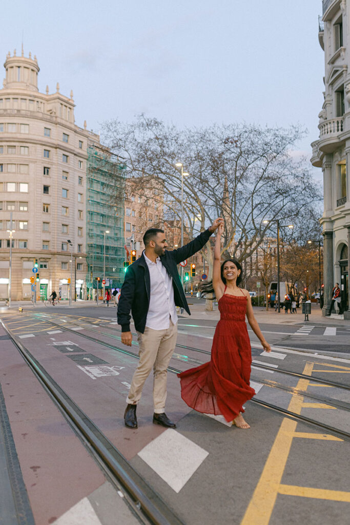Engaged couple dancing in the streets of Barcelona during their evening engagement session