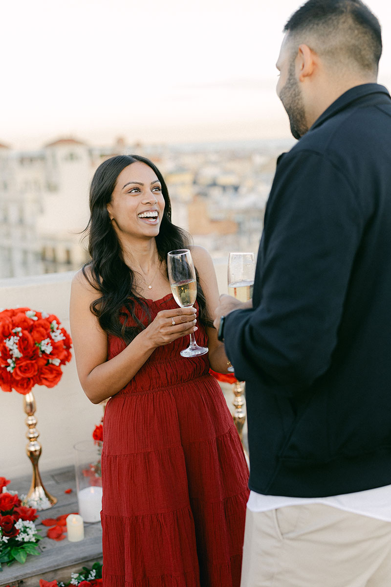 Couple celebrating a surprise proposal in Barcelona with champagne on a private rooftop terrace