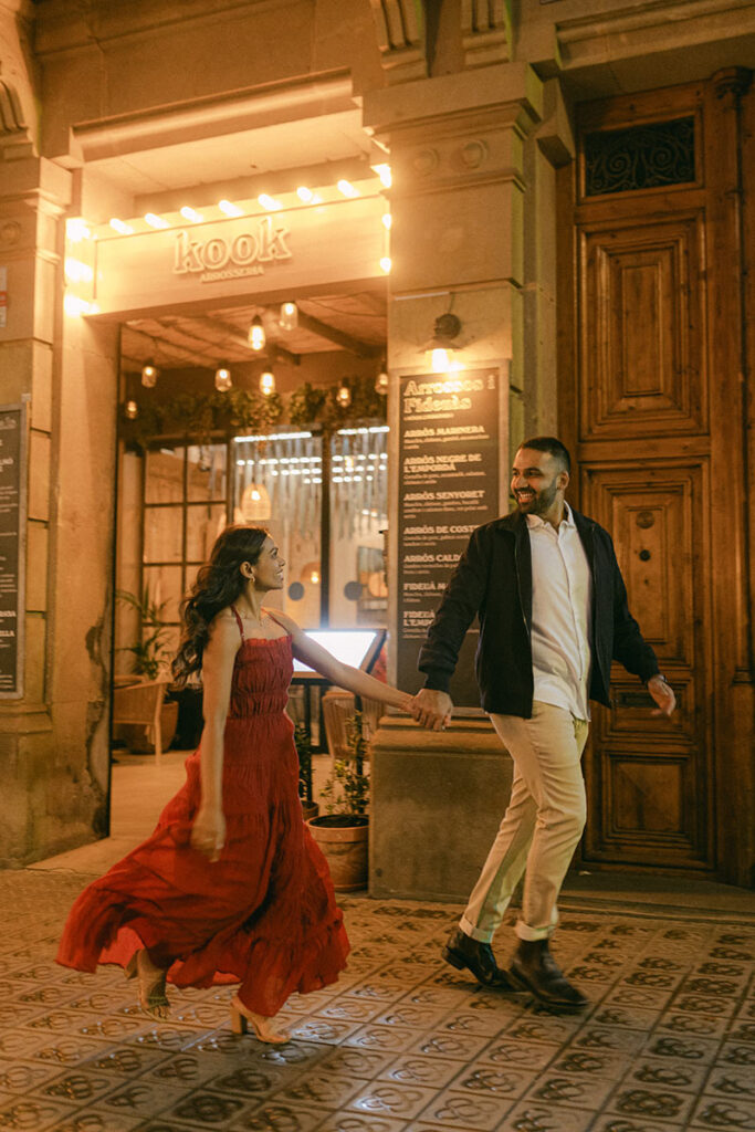 Engaged couple walking hand in hand through Barcelona after a surprise proposal