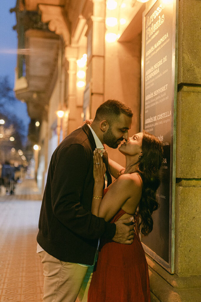 Engaged couple sharing a kiss during their Barcelona engagement photography session at night