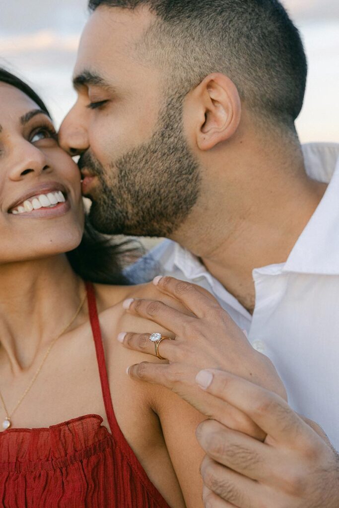 Engaged couple sharing a kiss after their surprise proposal in Barcelona