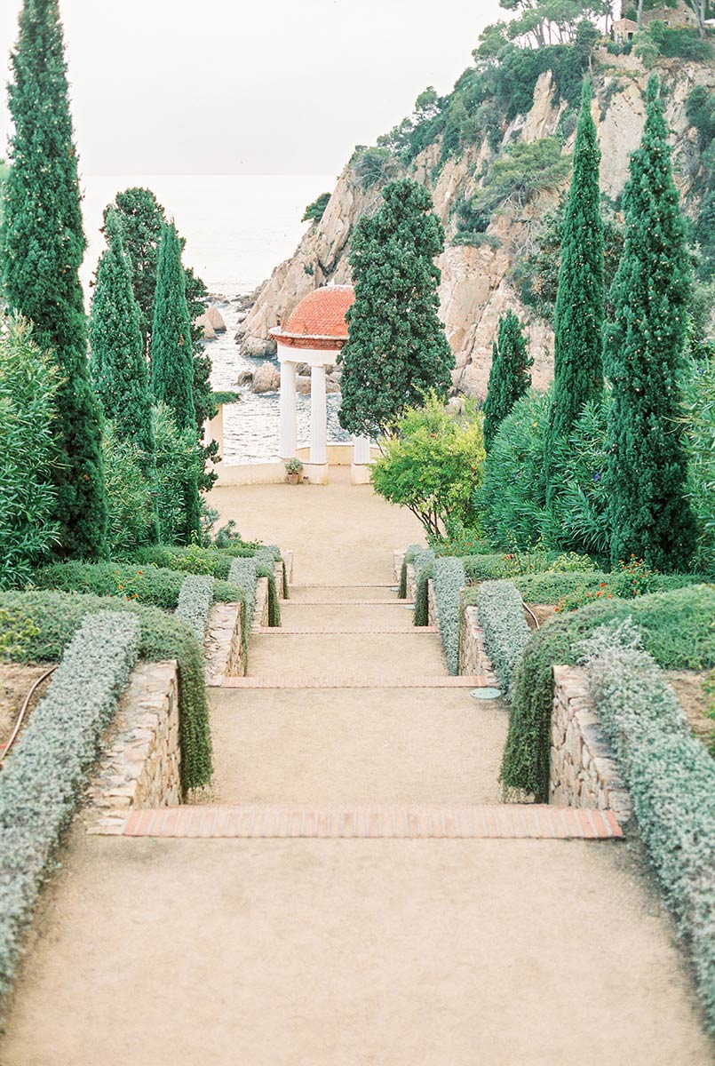 The long staircase leading towards the Linnaeus Temple at Marimurtra Botanical Garden, with the Mediterranean and the rocky coastline opening out behind it, ideal for surprise mariage proposal