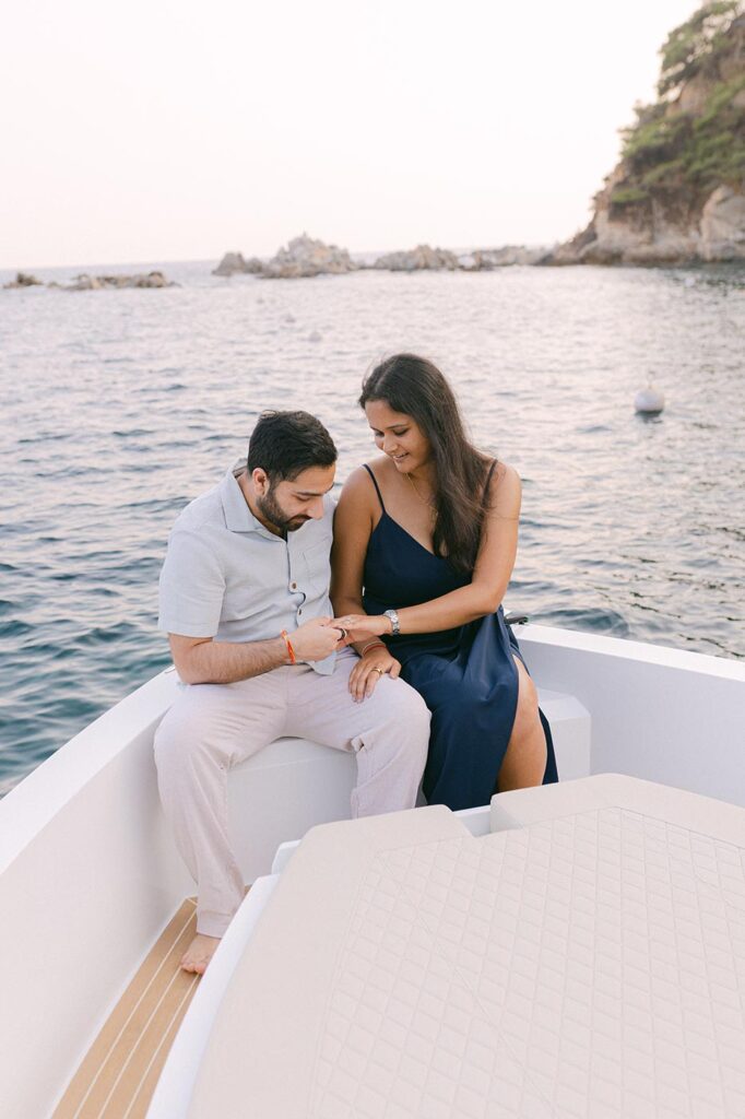 Couple watching an engagement ring after the surprise proposal on the private boat on Costa Brava