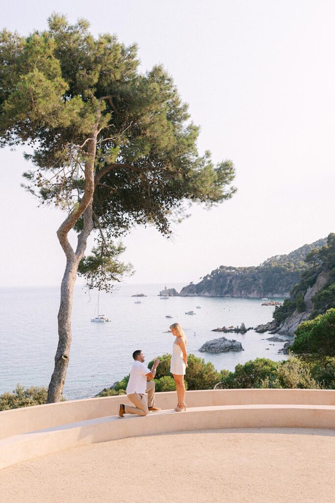 Man proposing on one knee to his love. Surprise proposal on the Costa Brava with the sea views at Santa Clotilde Garden, Lloret de Mar